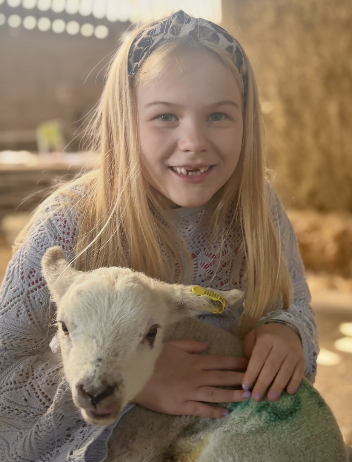 Amelie-lamb A photo of a young girl smiling and holding a lamb.